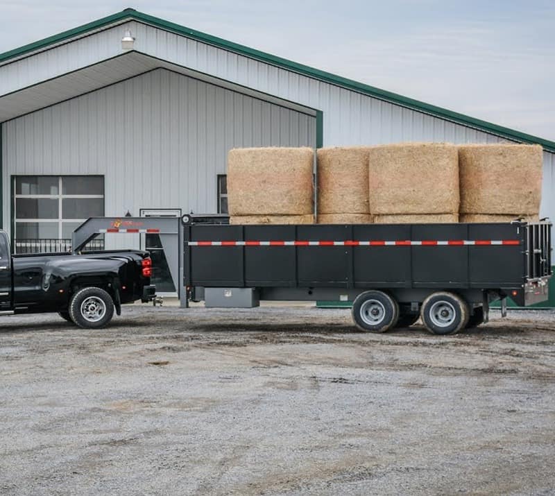 Large Black Heavy Duty Truck large black gooseneck trailer hauling bales of hay